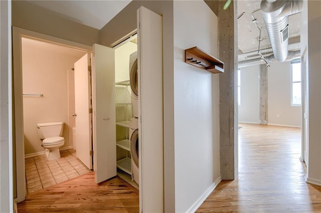 hallway featuring light hardwood / wood-style flooring and stacked washer and clothes dryer