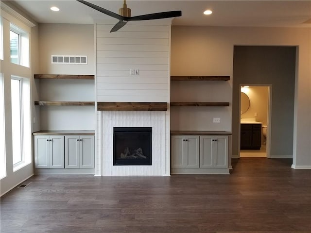 unfurnished living room with ceiling fan, a healthy amount of sunlight, and dark hardwood / wood-style floors