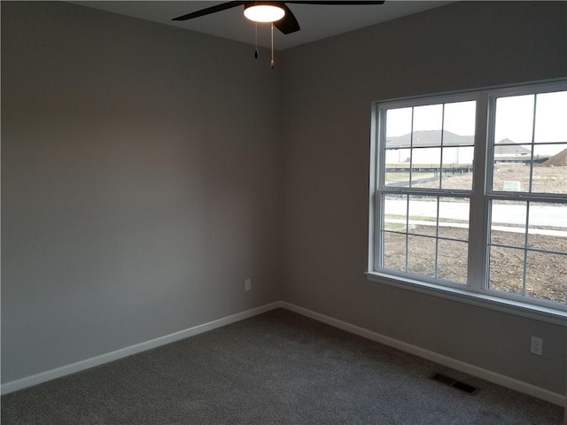 spare room with ceiling fan and carpet