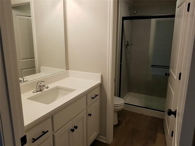 bathroom featuring vanity, hardwood / wood-style floors, toilet, and walk in shower