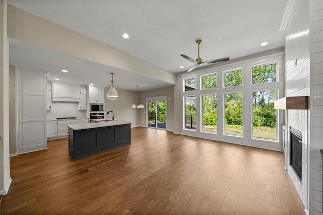 14566 Aurora Ln, Basehor, KS 66007 - kitchen featuring a ceiling fan, open floor plan, white cabinetry, a sink, and appliances with stainless steel finishes