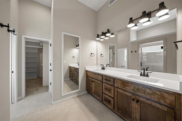 14566 Aurora Ln, Basehor, KS 66007 - full bathroom featuring a towering ceiling, a stall shower, double vanity, a walk in closet, and tile patterned flooring