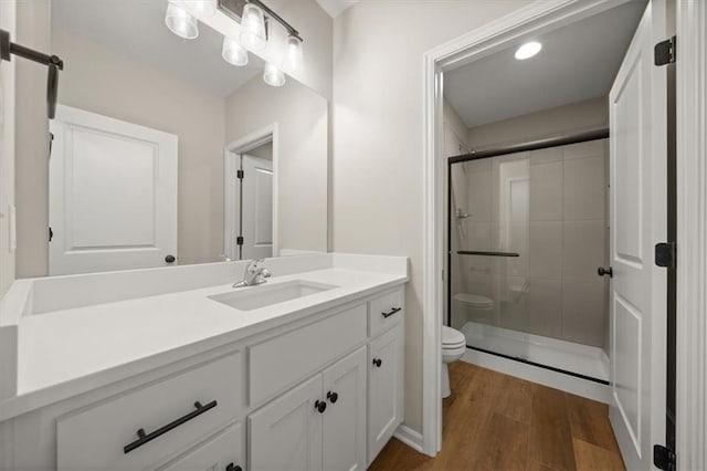 14566 Aurora Ln, Basehor, KS 66007 - bathroom with toilet, a stall shower, wood finished floors, and vanity