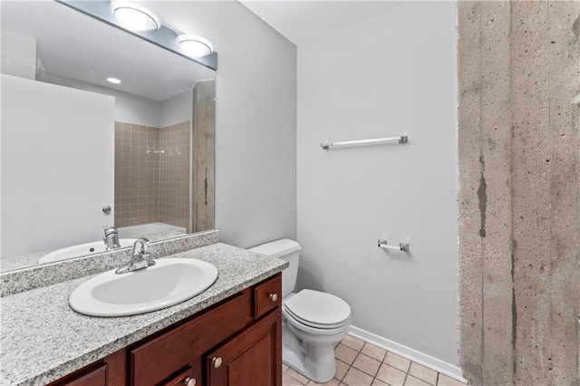 bathroom featuring a tile shower, tile patterned flooring, vanity, and toilet