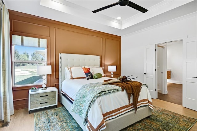 25110 W 98th Pl, Lenexa, KS 66227 - bedroom featuring wood finished floors, a decorative wall, a raised ceiling, ornamental molding, and ceiling fan