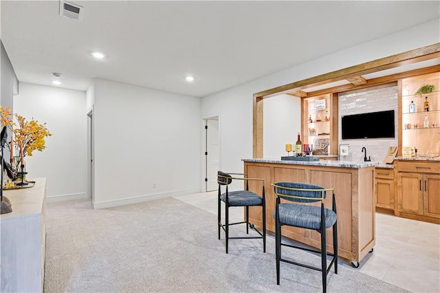 bar with light carpet and light stone countertops