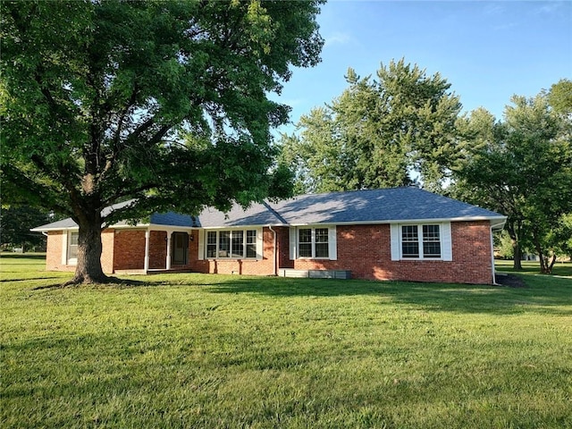 view of front of property featuring brick siding and a front yard