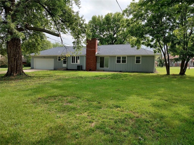 single story home featuring concrete driveway, central air condition unit, a chimney, a front lawn, and an attached garage