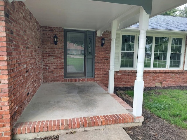 view of exterior entry featuring covered porch