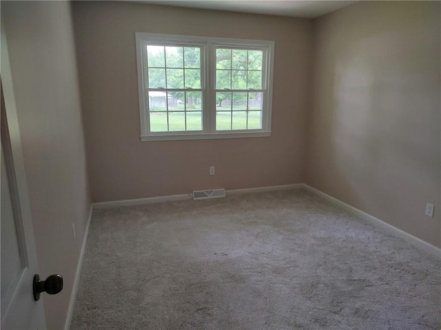 carpeted spare room with baseboards and visible vents