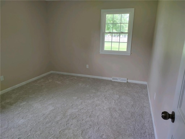 spare room with baseboards, carpet flooring, and visible vents