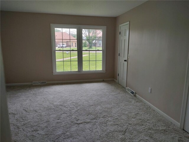 carpeted empty room with visible vents and baseboards