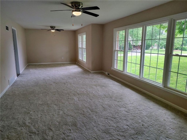 unfurnished room featuring ceiling fan, carpet flooring, and a healthy amount of sunlight