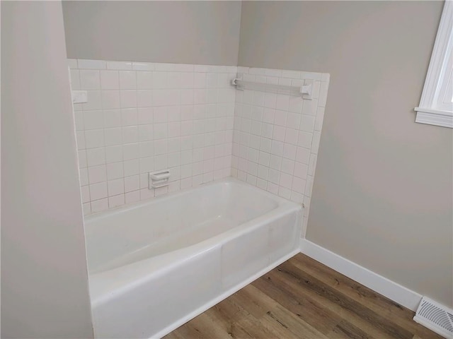 full bathroom featuring visible vents, baseboards, wood finished floors, and a bathtub
