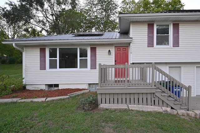 view of front of property with a garage, a wooden deck, and a front yard