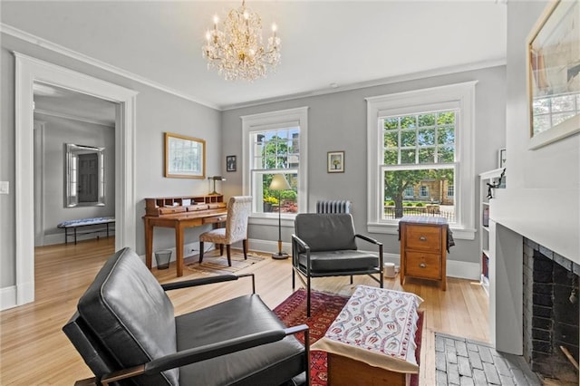 sitting room with crown molding, plenty of natural light, light hardwood / wood-style floors, and an inviting chandelier