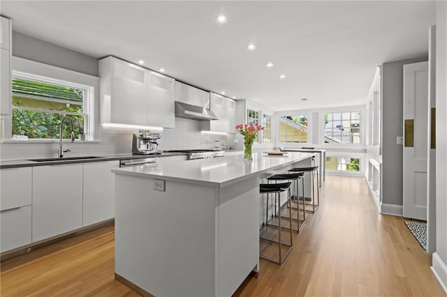 kitchen featuring white cabinetry, sink, and a kitchen island