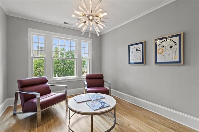 living area with hardwood / wood-style floors, a notable chandelier, and ornamental molding