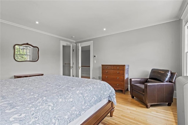 bedroom featuring crown molding and light hardwood / wood-style flooring