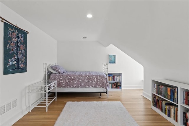 bedroom with lofted ceiling and wood-type flooring