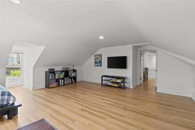 additional living space featuring light wood-type flooring and lofted ceiling