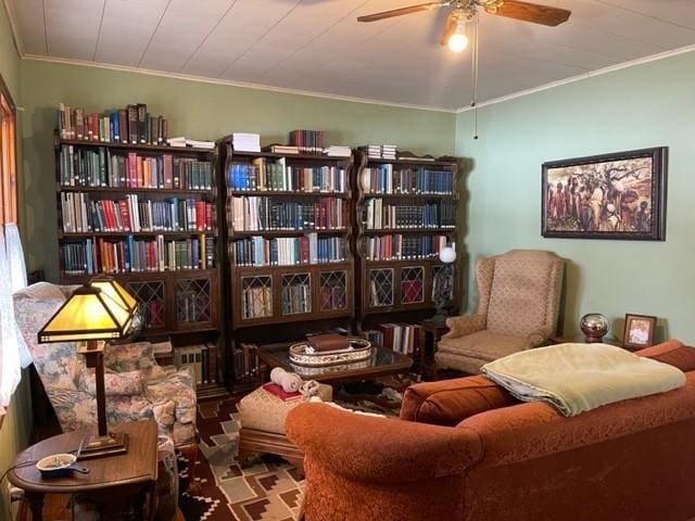 living area featuring ceiling fan and crown molding