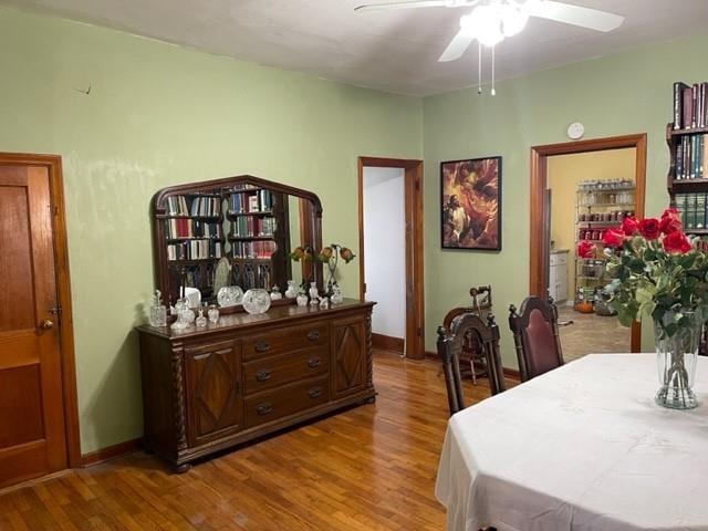 dining room with ceiling fan, light wood-style flooring, and baseboards