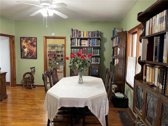 dining area with light wood-type flooring, ceiling fan, and baseboards