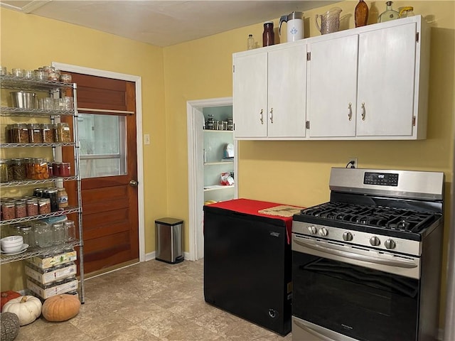 kitchen with white cabinetry, baseboards, and gas range