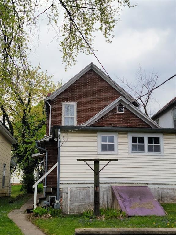 back of property featuring entry steps and brick siding