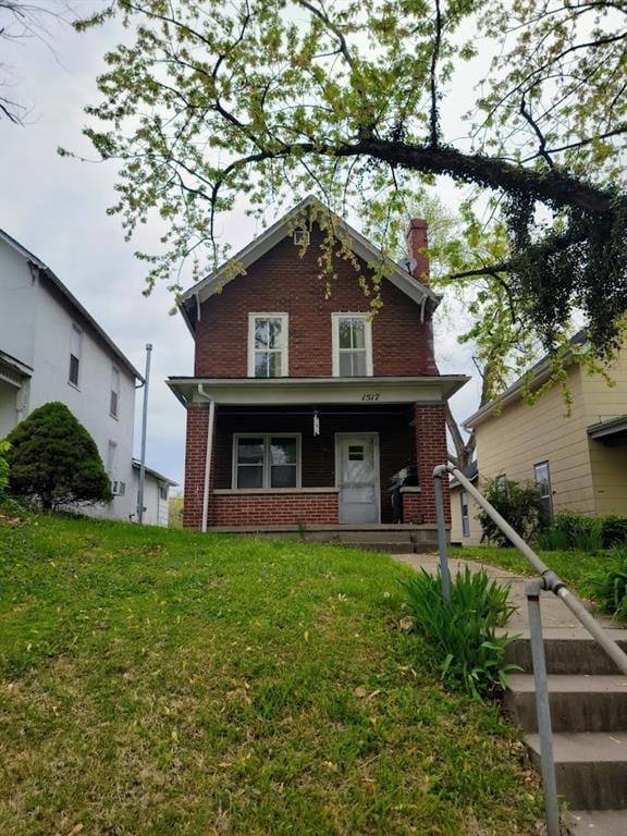 traditional-style house with a chimney, a front lawn, and brick siding