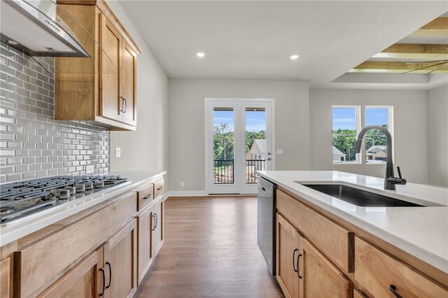 kitchen with sink, light hardwood / wood-style flooring, backsplash, stainless steel appliances, and light brown cabinetry