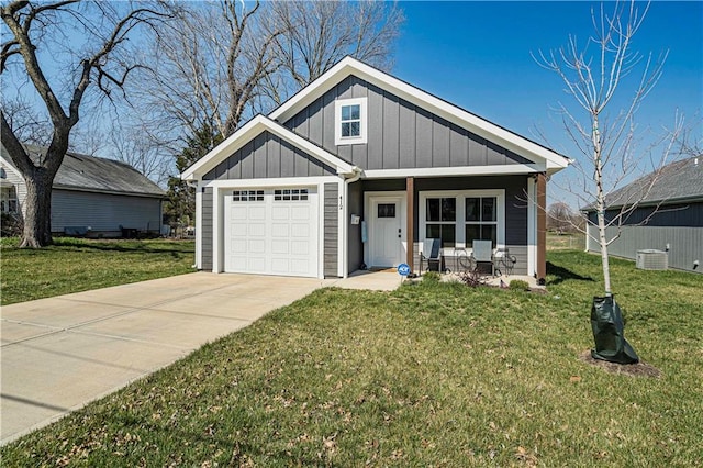 view of front of property featuring a front yard, a garage, covered porch, and central air condition unit