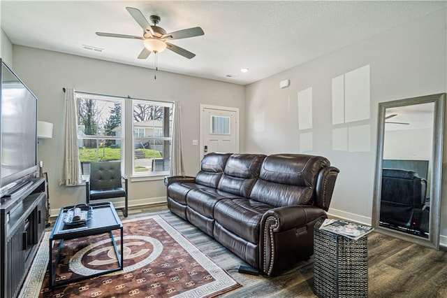 living room with dark hardwood / wood-style flooring and ceiling fan