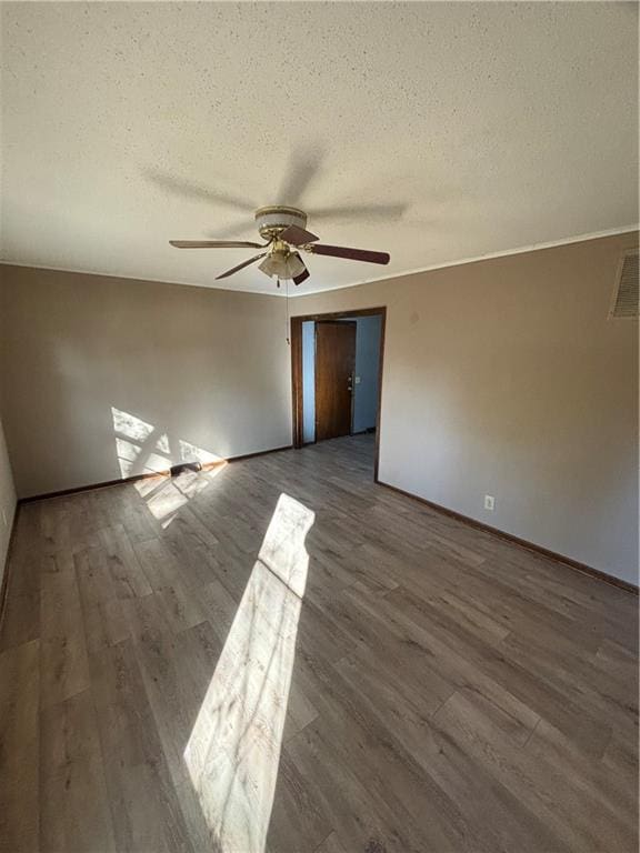 empty room featuring a textured ceiling, hardwood / wood-style flooring, and ceiling fan