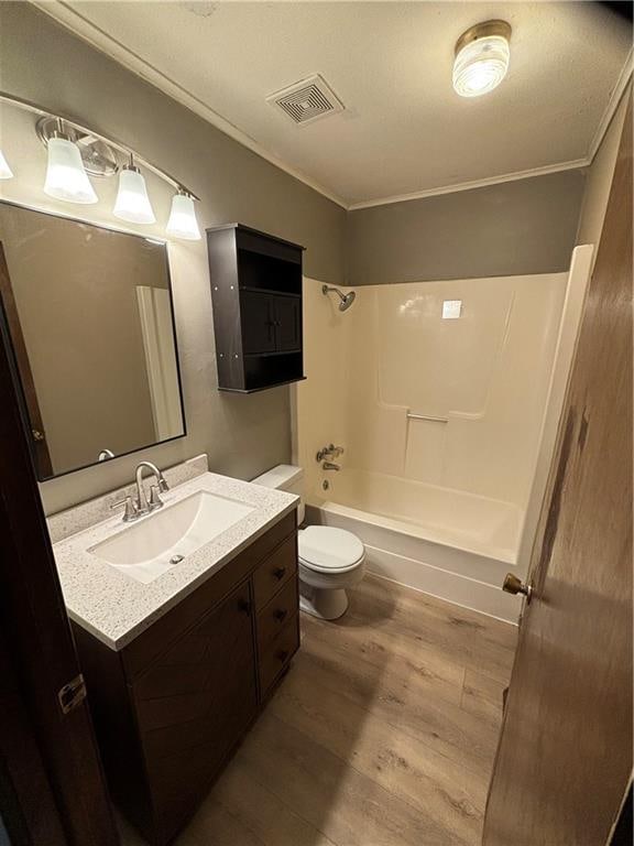 full bathroom featuring wood-type flooring, crown molding, vanity, shower / tub combination, and toilet