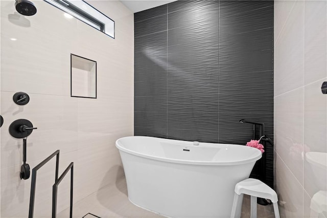 bathroom featuring tile walls and a bath