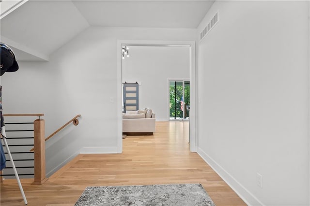 hallway with lofted ceiling and hardwood / wood-style floors