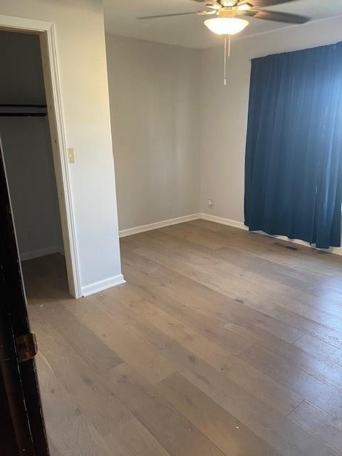 unfurnished bedroom with ceiling fan, hardwood / wood-style flooring, and a closet