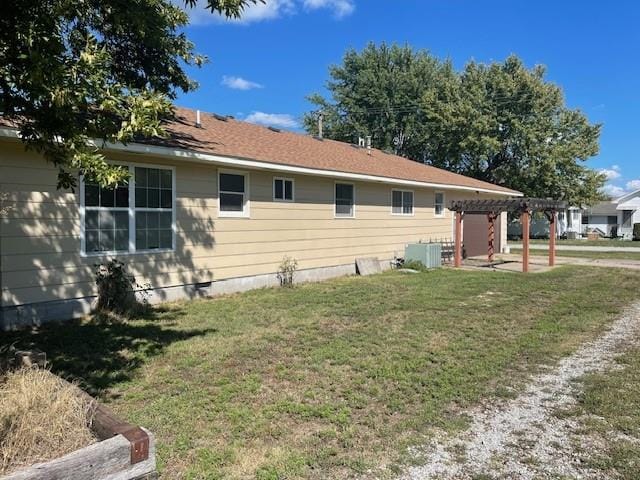 back of house featuring cooling unit, a yard, and a pergola