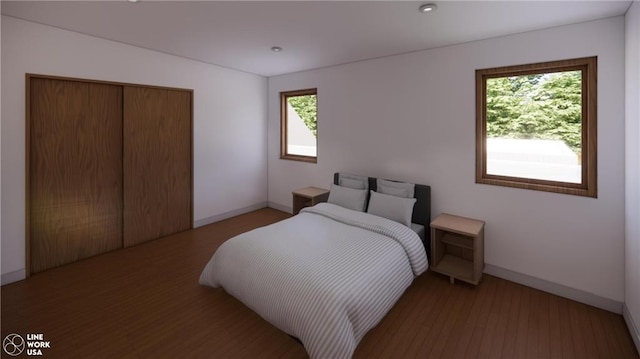 bedroom with a closet, wood-type flooring, and multiple windows