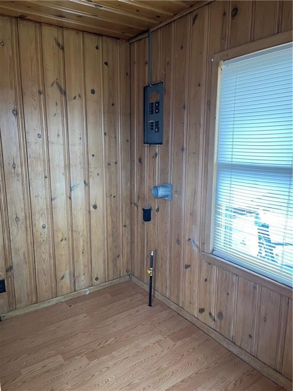 clothes washing area with wooden walls, wooden ceiling, and light hardwood / wood-style floors