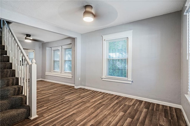 interior space with ceiling fan and dark hardwood / wood-style flooring