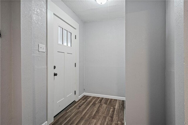 doorway featuring a textured ceiling and dark wood-type flooring