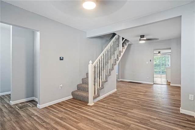 stairway featuring wood-type flooring and ceiling fan