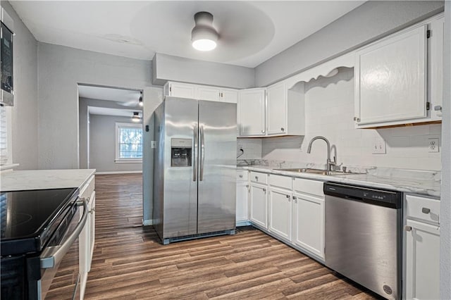 kitchen with appliances with stainless steel finishes, hardwood / wood-style floors, sink, and white cabinets