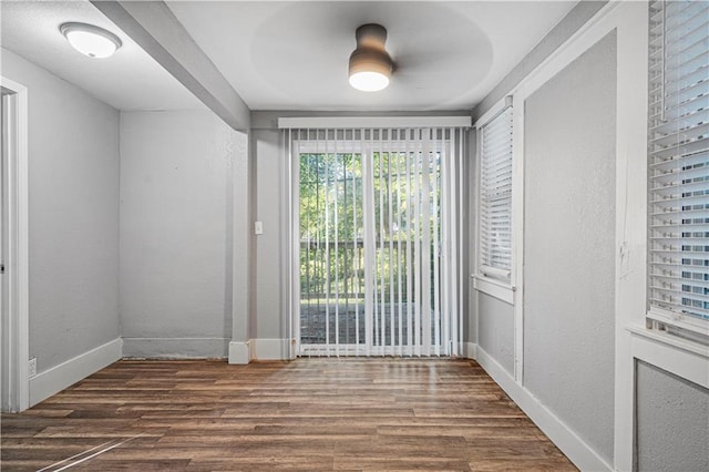 spare room featuring ceiling fan and dark wood-type flooring