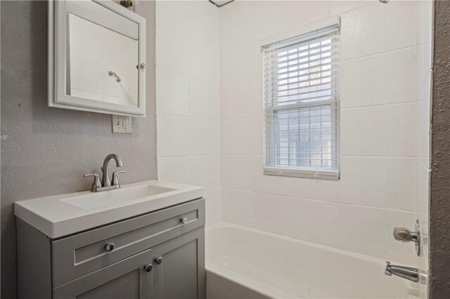 bathroom with vanity and tiled shower / bath