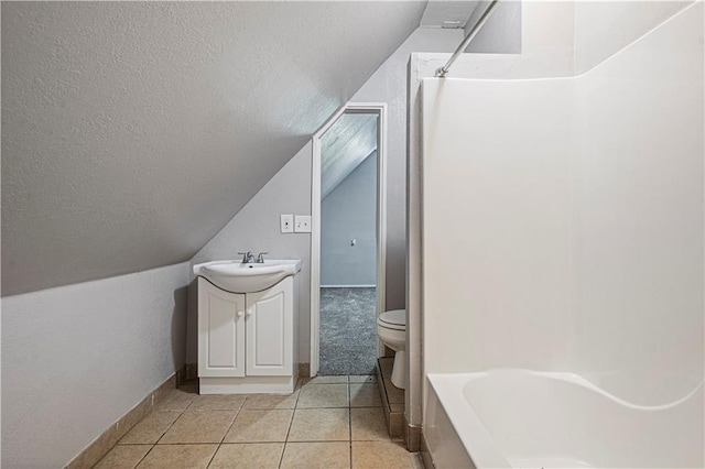 full bathroom featuring vanity, lofted ceiling, tile patterned flooring, toilet, and bathtub / shower combination