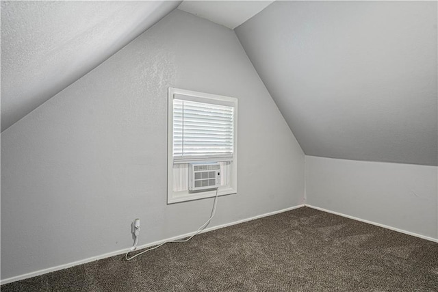 bonus room with cooling unit, a textured ceiling, lofted ceiling, and carpet flooring